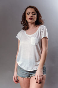 Portrait of a beautiful young woman against gray background