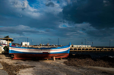 Boats moored at beach against sky