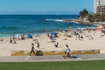 People at beach against sky