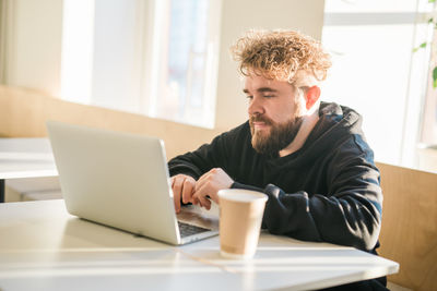 Young woman using laptop at table