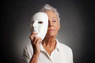 Portrait of man wearing mask against black background