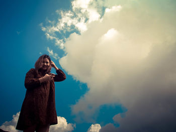 Low angle view of woman standing against sky