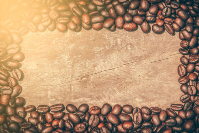 A large number of coffee beans are placed on an old wooden board 