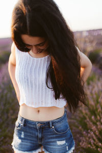 Happy brunette woman in a lavender field looking down