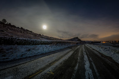 Panoramic view of snow covered landscape against sky at night