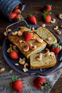 Banana cake with cashew and strawberry as topping on table