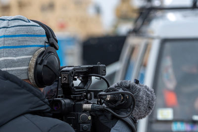 Rear view of man holding video camera