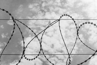 Low angle view of fence against sky