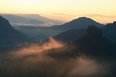 Cold morning at the end of summer. colorful summer morning with golden light and fog between hills