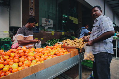 Man and fruits for sale at market stall