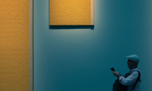 Rear view of woman looking through window