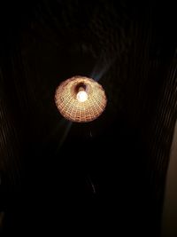 Low angle view of illuminated pendant light in the dark