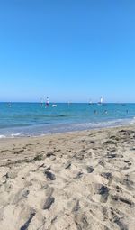 Scenic view of beach against clear blue sky