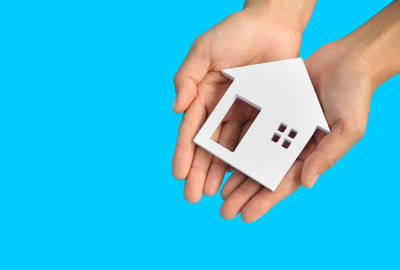 Midsection of person holding paper against blue background