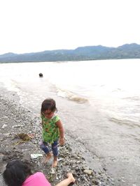 Full length of girl on beach against sky