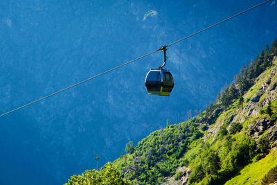 Low angle view of overhead cable car against sky