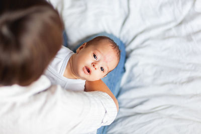 Mother comforts her little son or daughter. baby with a big birthmark on forehead.