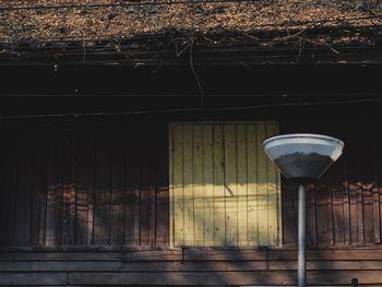 Empty illuminated street against wall in city