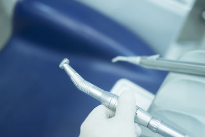 Cropped hand of dentist holding dental equipment