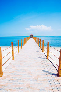 Pier over sea against blue sky