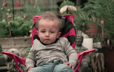 Portrait of cute boy sitting outdoors