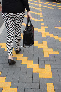 Low section of man walking on zebra crossing