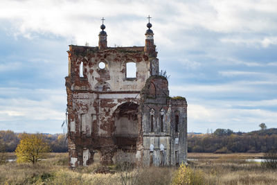 Old ruin building on field against sky