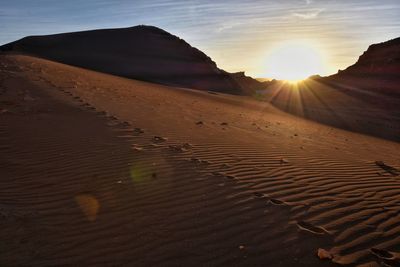 Scenic view of desert against sky during sunset