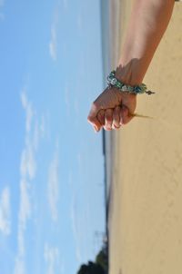 Midsection of woman holding umbrella against sky