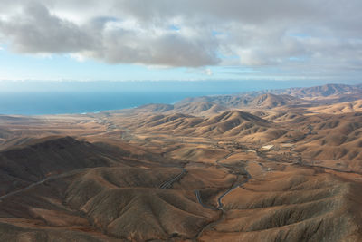 A winding mountain road captured from above, snaking through the volcanic terrain near sicasumbre