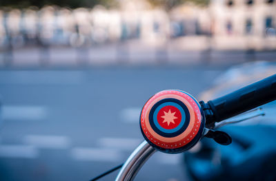 Close-up of bicycle wheel with city in background