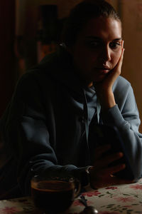 Portrait of young man sitting on table