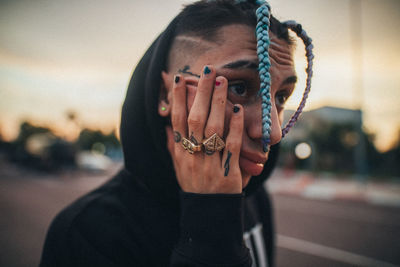 Portrait of young man against sky in city