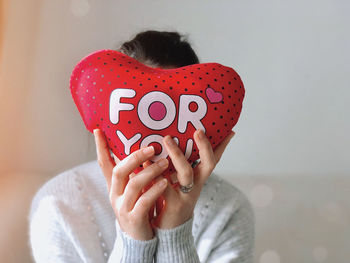 Midsection of woman holding heart shape