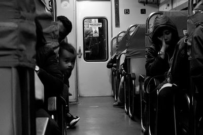 Full length of men sitting in train