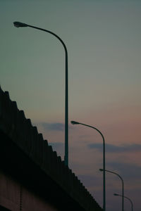 Low angle view of street lights against sky during sunset