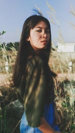 Portrait of woman standing against sky