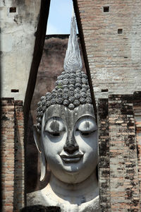 Close-up of buddha statue amidst built structure