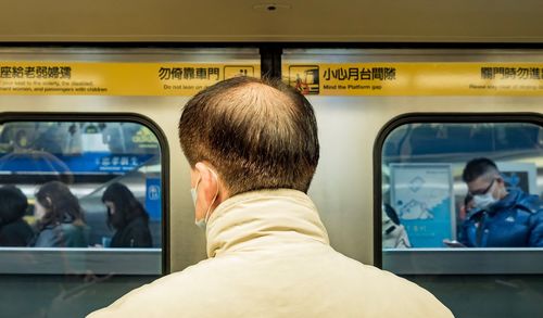 Rear view of man traveling in train