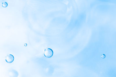 Low angle view of bubbles against blue sky