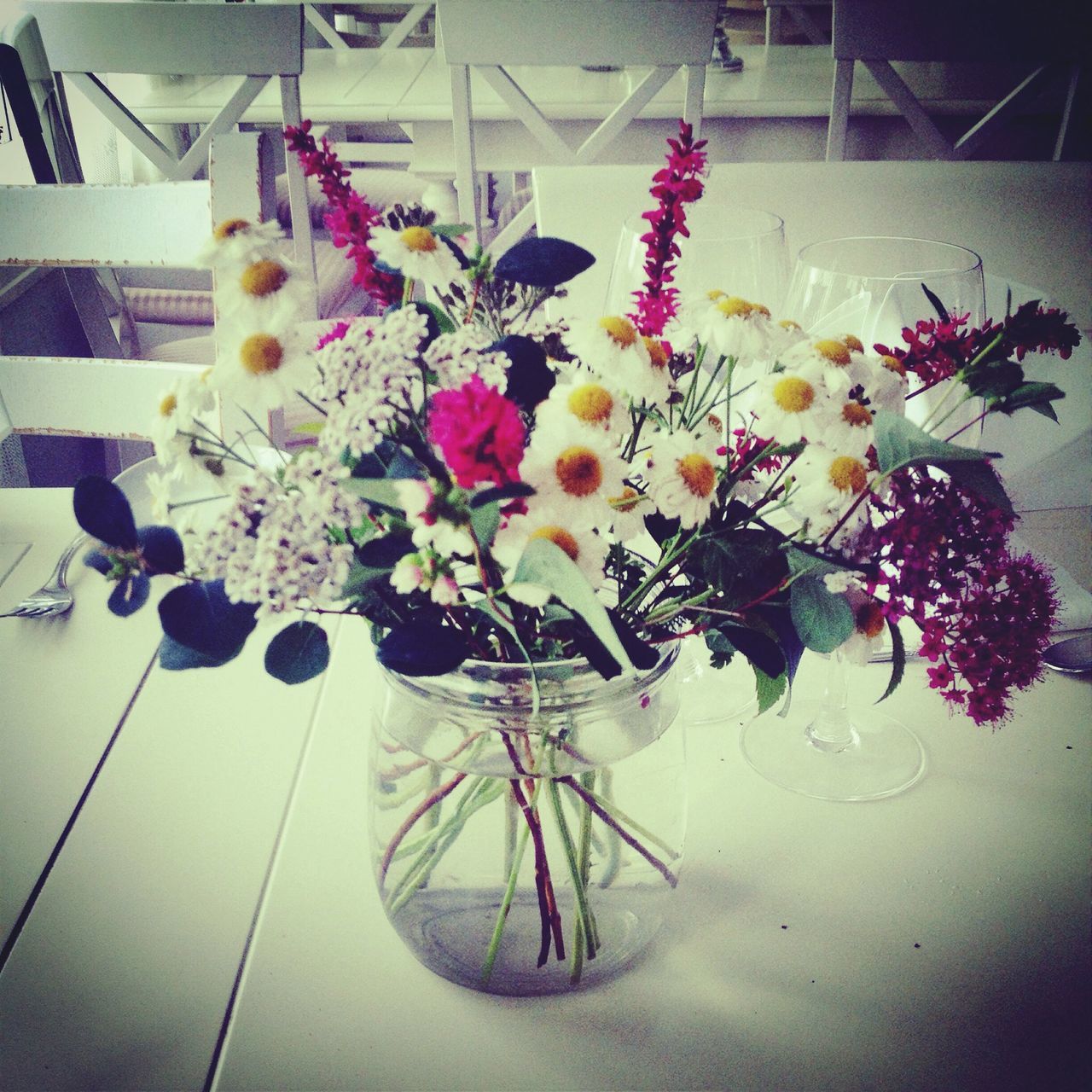 indoors, table, flower, high angle view, decoration, still life, variation, vase, freshness, home interior, glass - material, no people, fragility, arrangement, flower arrangement, chair, large group of objects, reflection, plate, multi colored