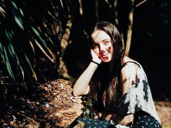 Portrait of a smiling young woman sitting outdoors