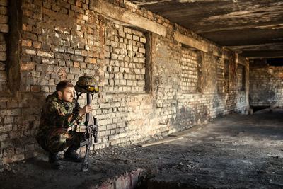 A thoughtful soldier, resting from a military operation location of ruins