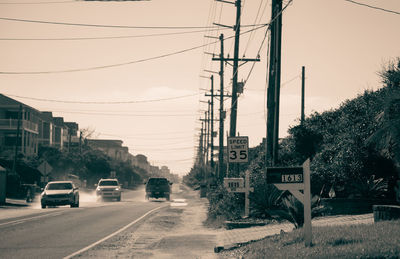 Cars on road against sky in city