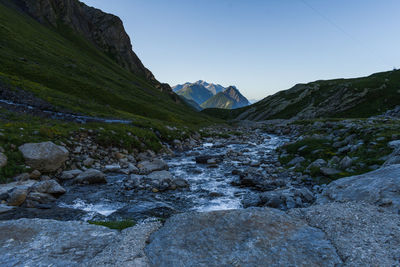 Scenic view of stream amidst rocks against sky