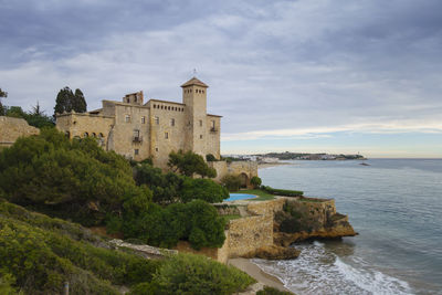 Historic building by sea against sky