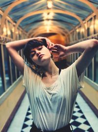 Full length of young woman standing in corridor