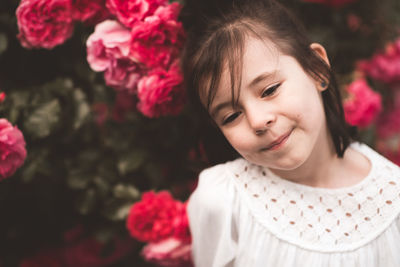 Pretty smiling baby girl 3-4 year old posing over floral roses background 