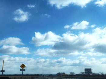 Low angle view of road sign against sky