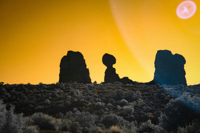 Low angle view of silhouette rock formation against sky
